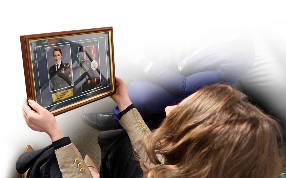 A service person inspecting her framed medals